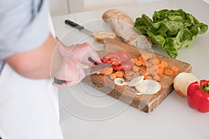 Man hands cutting vegetables in the kitchen
