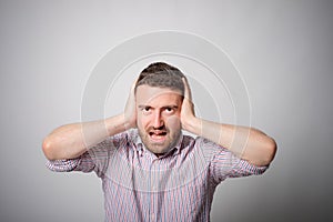 Man with hands on ears bothered photo