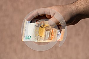 Man hands giving money like a bribe or tips. Holding EURO banknotes on a blurred background, EU currency