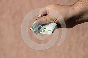 Man hands giving money like a bribe or tips. Holding EURO banknotes on a blurred background, EU currency