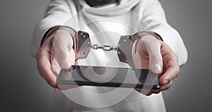 Man hands handcuffs holding smartphone. Internet and Social Media addiction