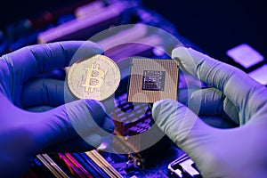 Man hands hold gold Bitcoin and cpu on motherboard background. Person shows future currency. Mining, trading