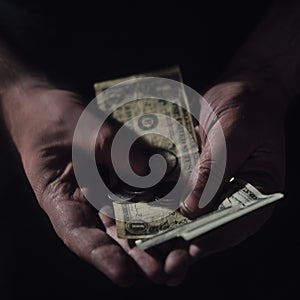 Man hands hold money US dollars on a black background, close-up. US