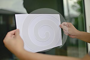 Man hands holding a blank white paper, ready with copy space.