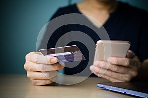 Man hands holding credit card and smart phone for online shopping paying online, using banking service