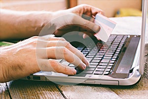 Man Hands holding credit card and using laptop