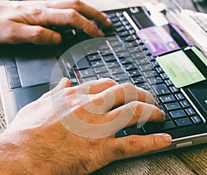 Man Hands holding credit card and using laptop