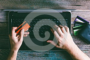 Man Hands holding credit card and using laptop in the evening