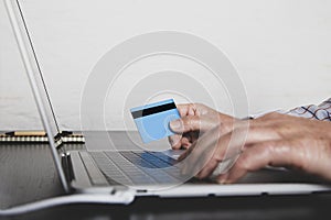 Man hands holding credit card and using laptop. Online purchases. Online shopping