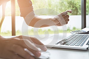 A man hands holding credit card and using laptop. Online shopping