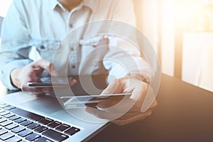 A man hands holding credit card and using laptop. Online shopping, Online payment with credit card concept