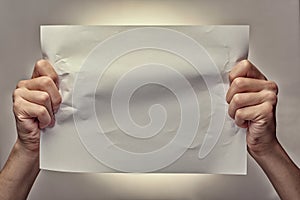 Man hands holding a crumpled blank piece of paper