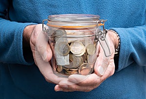 Man hands holding jar full of euro money, pension fund concept, coins and banknotes