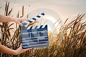 Man hands holding movie clapper isolated on nature background.
