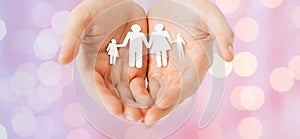 Man hands holding paper cutout of family