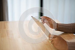 Man hands holding smart tablet with laptop keyboard Young man freelance hands typing on laptop keyboard working computer in home