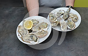 Man hands with lemon and oyster.