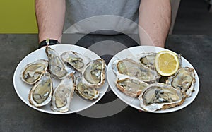 Man hands with lemon and oyster.