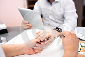 Man hands manicure treatment with emery board