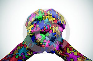 Man hands patterned with puzzle pieces of different colors