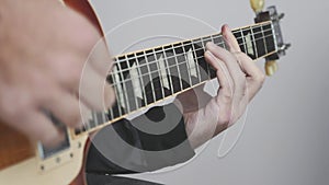 Man hands playing electric or acoustic guitar. Playing rock and blues chords on guitar. Hands, fingers on guitar fretboard
