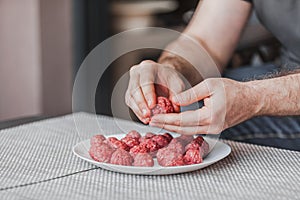 Man hands preparing meatballs with raw mincemeat