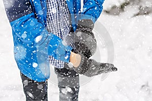 Man hands put on warm gloves on a winter cold day f