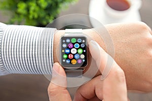 Man hands smart touch watch with home screen icons apps