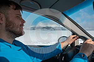 Man hands on steering wheel winter road trip