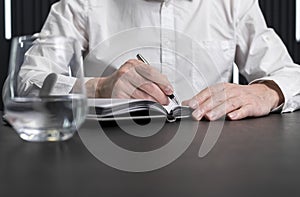 Man hands taking notes in planner. Employee sitting at desk and writing plans. Business planning concept.