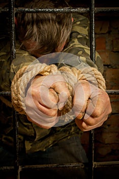 Man with hands tied with rope