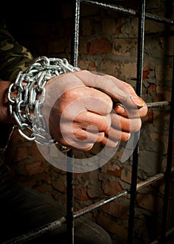 Man with hands tied up with chains