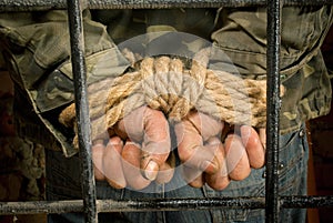 Man with hands tied up with rope