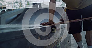 Man hands touching skateboard wheels at skate park. Riding skate board wheel.