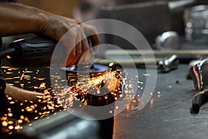 Man hands treating metal parts of hardware in a workshop with an