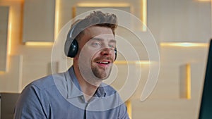 Man hands typing keyboard in office close up. Happy businessman in headphones