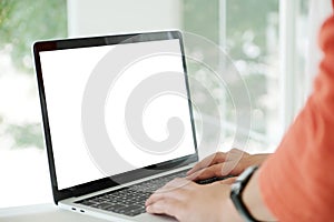 Man hands typing laptop computer with blank screen for mock up t