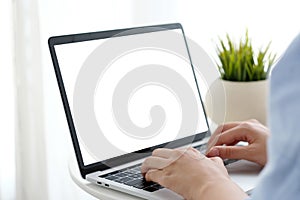 Man hands typing laptop computer with blank screen for mock up t