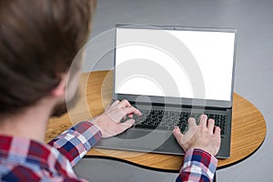 Man hands typing on laptop keyboard with white blank screen - mockup image