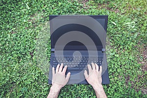 Man hands typing on laptop in outdoor.