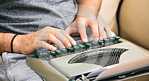 Man hands typing on a vintage typewriter.