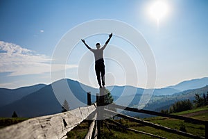 Man with hands up on top of mountains