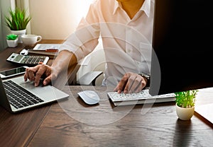 Man hands using keyboard of laptop computer on office desk.