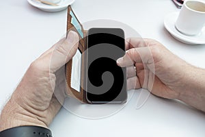 Man hands using mobile phone on a table with coffee with copy space