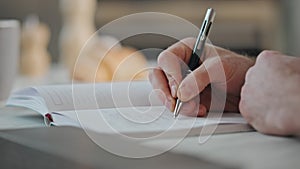 Man hands writing notepad at home close up. Student studying noting information