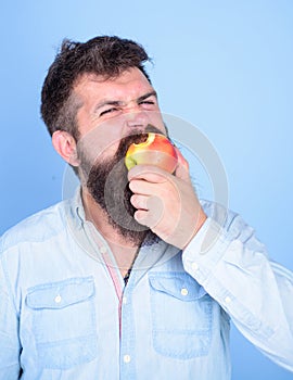 Man handsome hipster with long beard eating apple. I love apples Man diet nutrition eats fruit. Hipster hungry bites