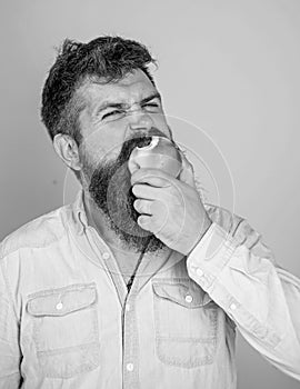 Man handsome hipster with long beard eating apple. I love apples Man diet nutrition eats fruit. Hipster hungry bites