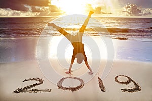 man handstand on the beach.happy new year 2019 concept