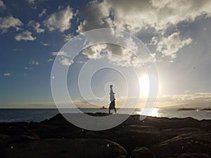 Man Handstand on Rocks along the water at sunset
