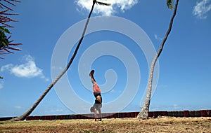 Man Handstanding in the grass along cliff shore next to shallow